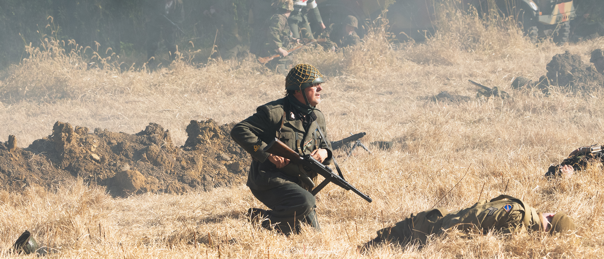 "Soldier in a field during World War II, armed with a PPSh-41 submachine gun. The soldier, dressed in standard military attire, crouches in a defensive position, surveying the landscape for threats. The iconic curved magazine of the PPSh is prominently displayed, symbolizing the fierce combat of the Eastern Front. The backdrop of a war-torn field adds to the intensity of the moment, emphasizing the soldier's readiness and the challenges faced during the conflict. This image encapsulates the essence of soldiering in one of history's most turbulent times."